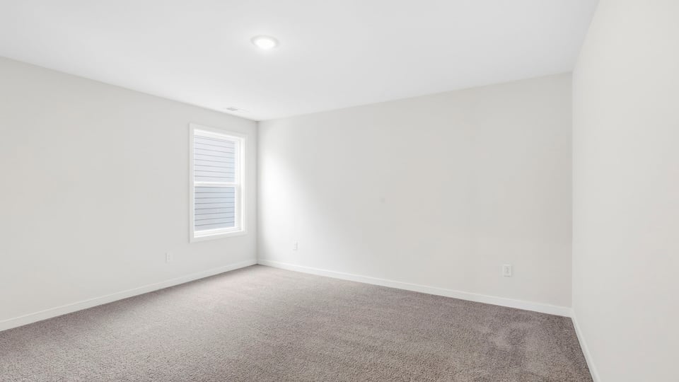 Bedroom with carpet and window.
