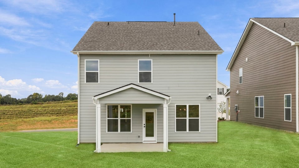 Back exterior of home with large backyard.
