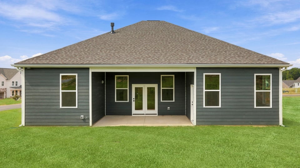Back exterior of home with large backyard.