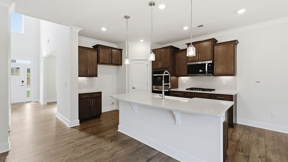 Kitchen and island with quartz countertops and stainless steel appliances.