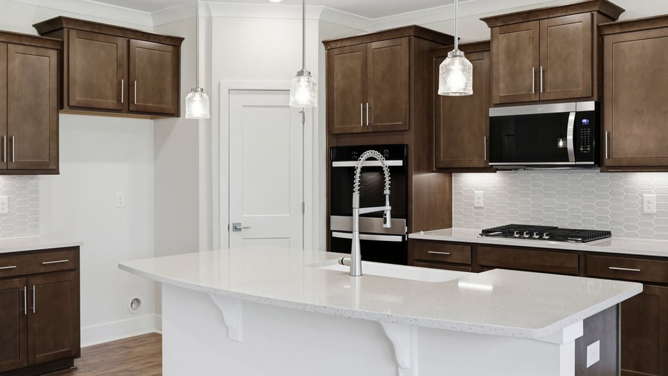 Kitchen and island with quartz countertops and stainless steel appliances.