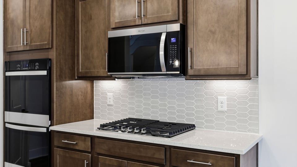 Kitchen and island with quartz countertops and stainless steel appliances.