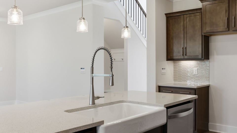 Kitchen and island with quartz countertops and stainless steel appliances.