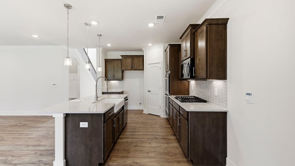 Kitchen and island with quartz countertops and stainless steel appliances.