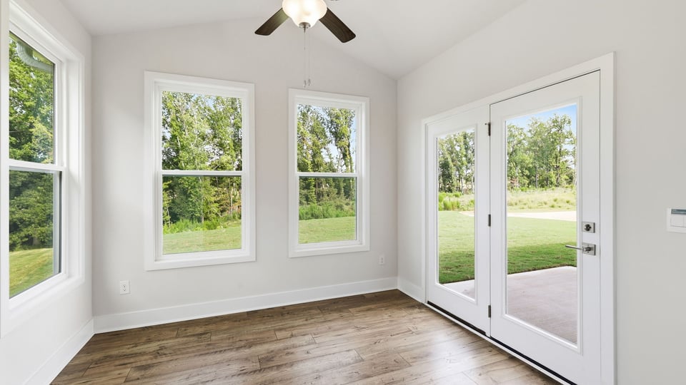 Sunroom with windows and door to backyard.
