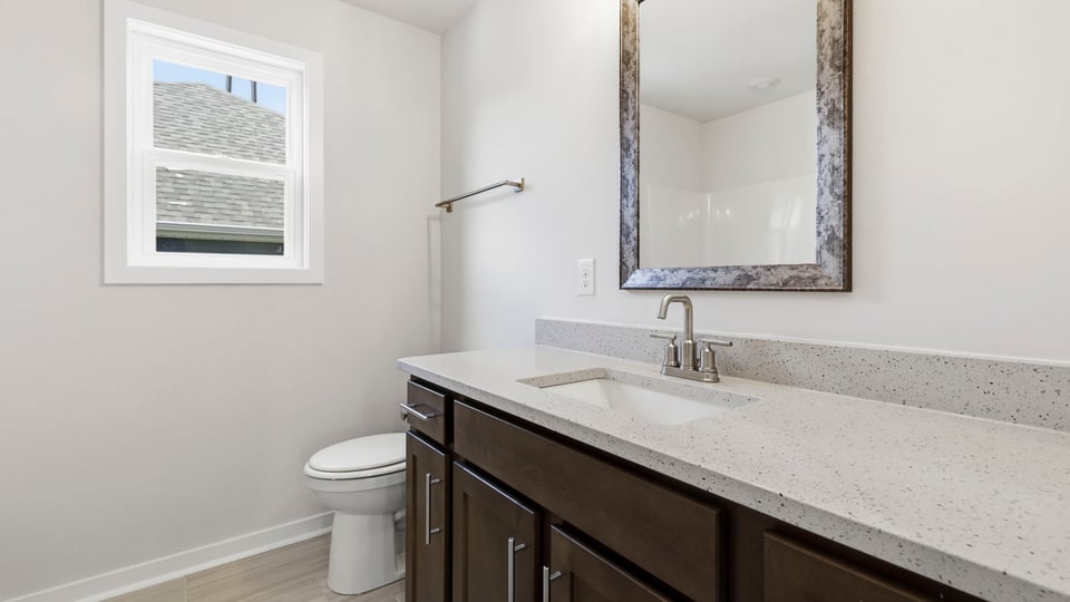 bathroom with double vanity sink and window.