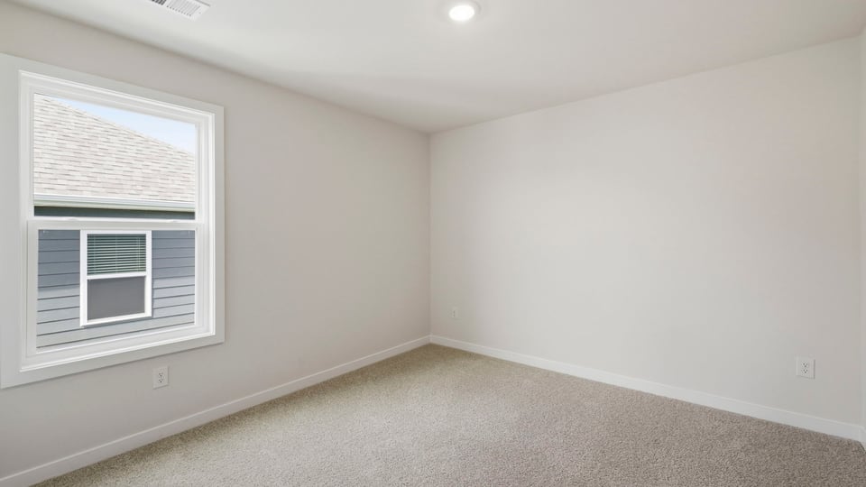 Bedroom with carpet and window.