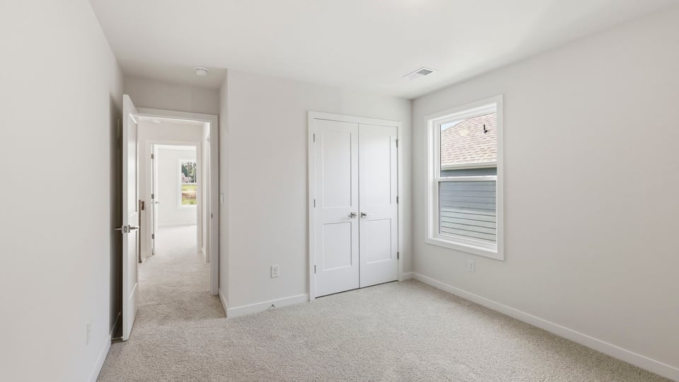 Bedroom with carpet and window.