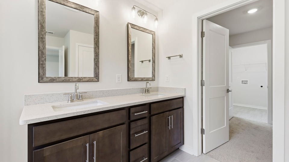 Bathroom with double vanity sink and walk in closet.