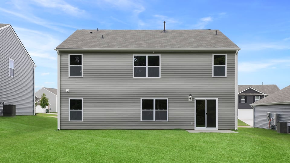 Back exterior of home with large backyard.