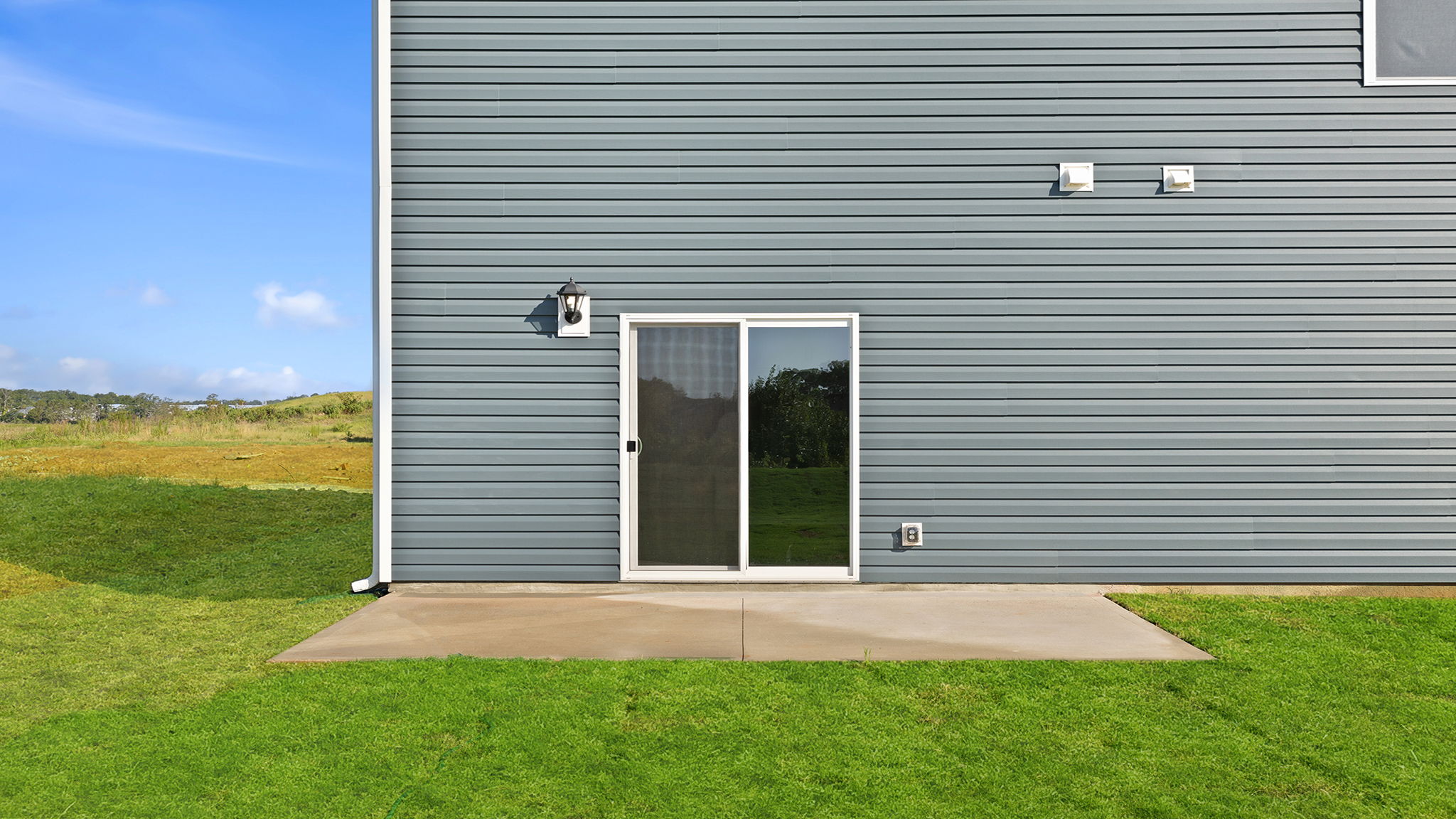 Back exterior of home with patio.