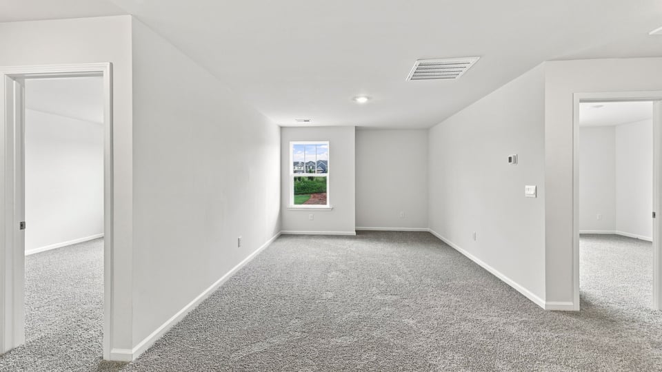 Loft area with carpet and window.