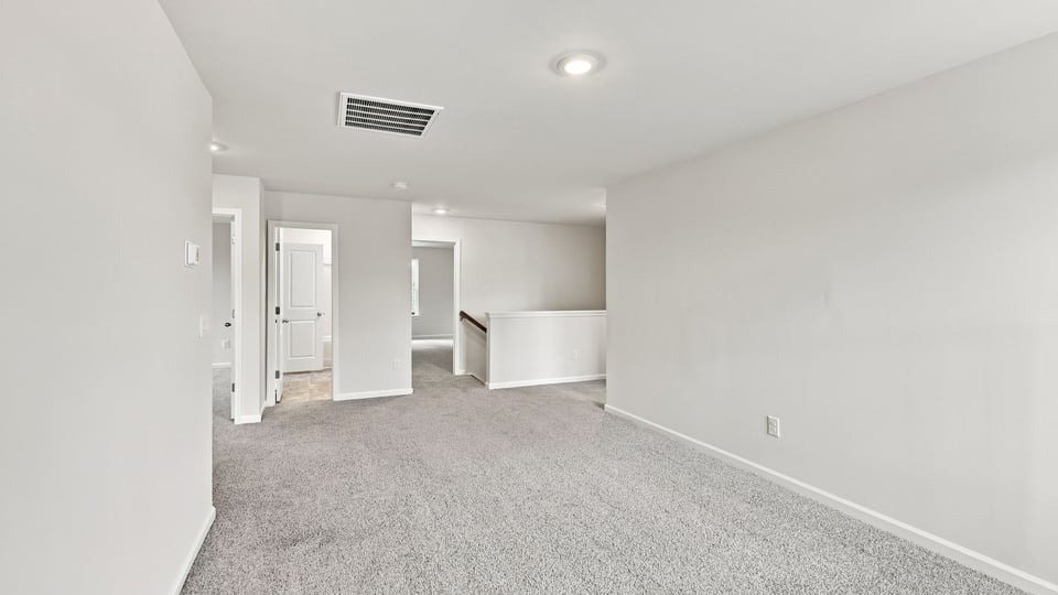 Loft area with carpet and window.