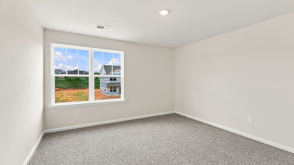 Bedroom with carpet and window.