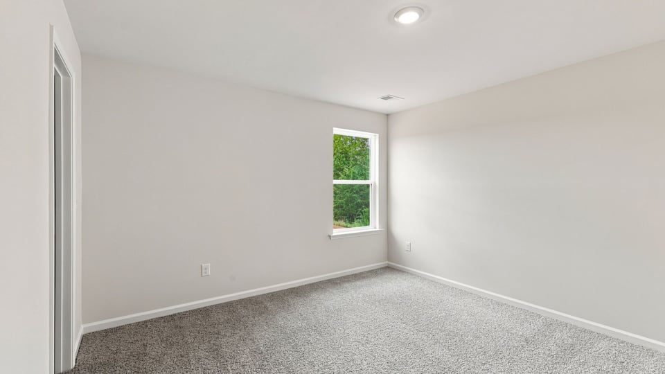 Bedroom with carpet and window.