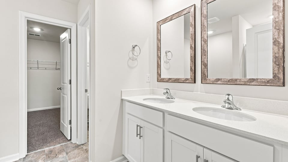 Bathroom with double vanity sink and walk in closet.