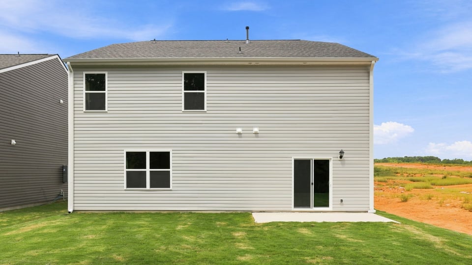 Back exterior of home with large backyard.