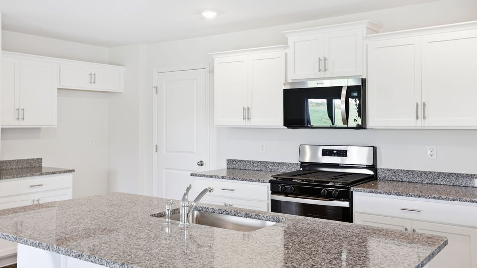 Kitchen and island with quartz countertops.
