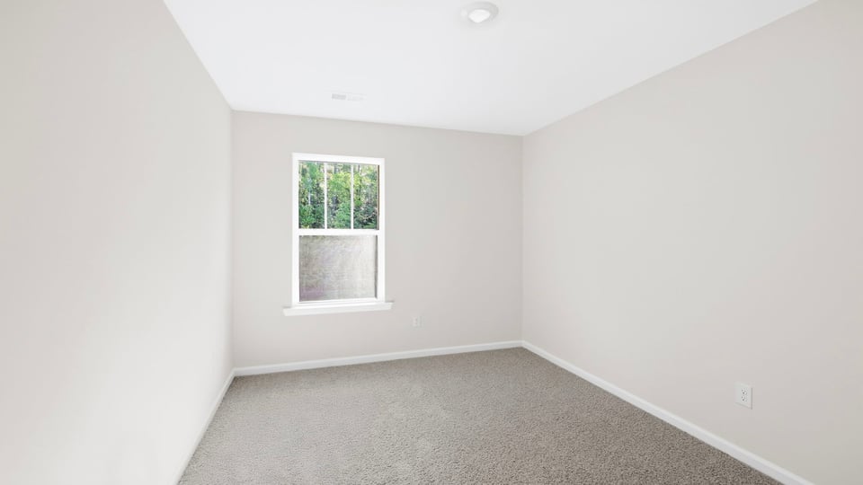 Bedroom with carpet and window.