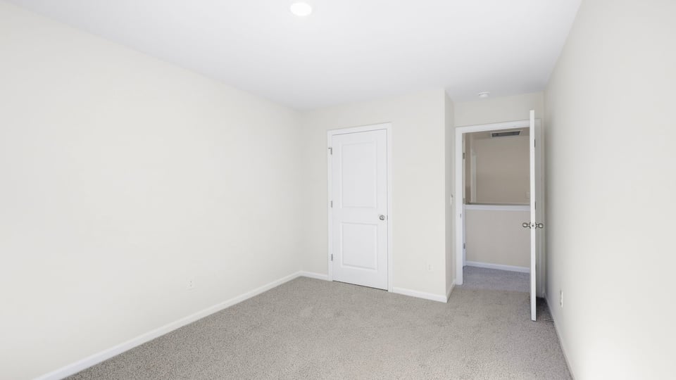 Bedroom with carpet and window.