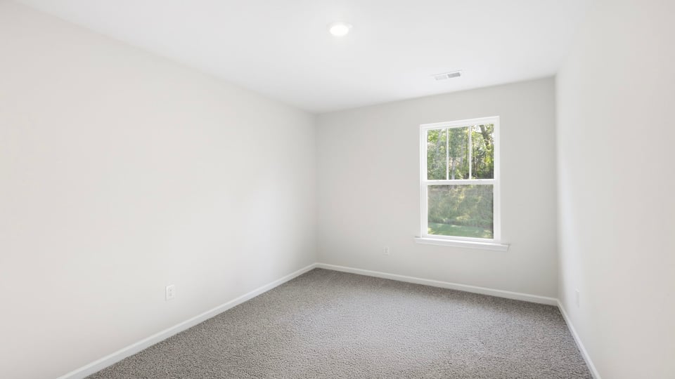 Bedroom with carpet and window.