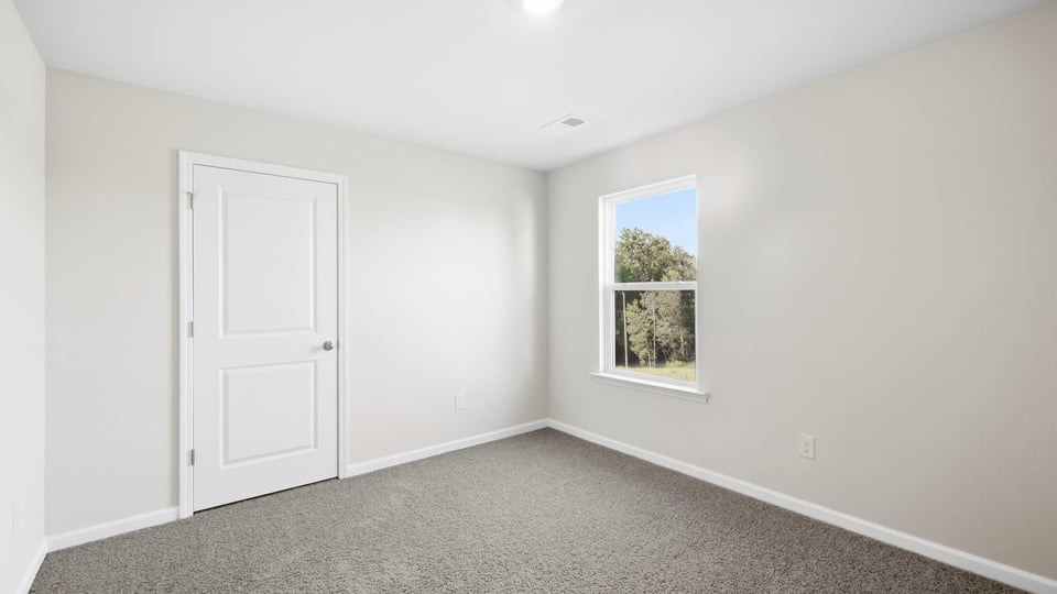 Bedroom with carpet and window.