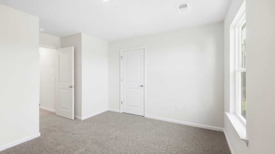 Bedroom with carpet and window.