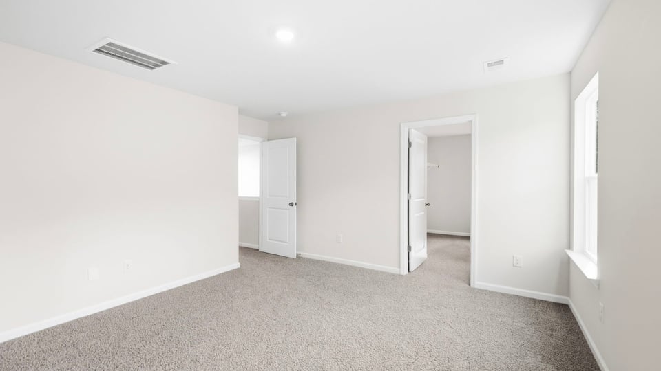 Bedroom with carpet and window.