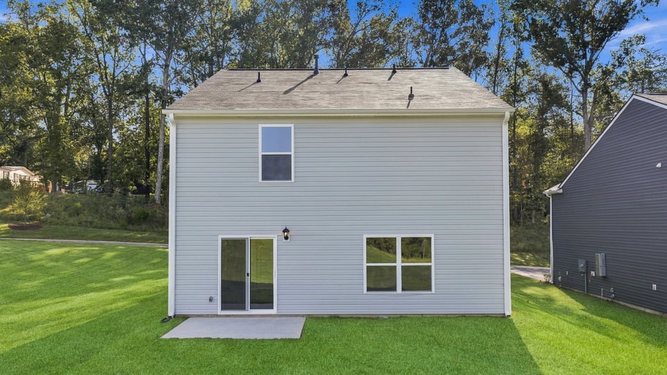 Back exterior of home with large backyard.