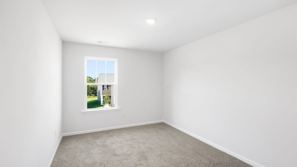 Bedroom with carpet and window.