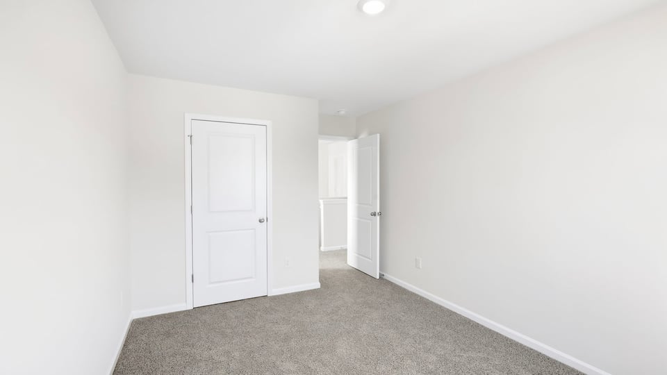 Bedroom with carpet and window.