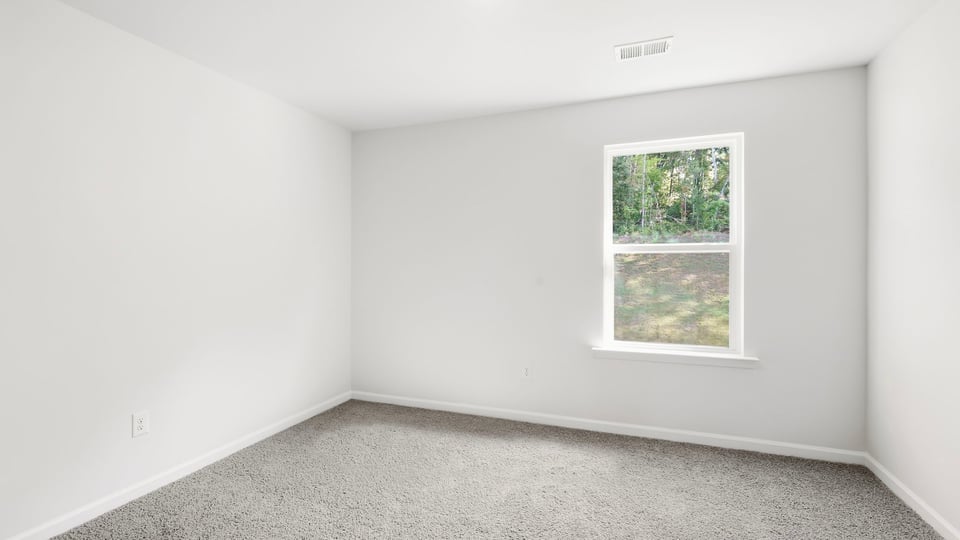 Bedroom with carpet and window.
