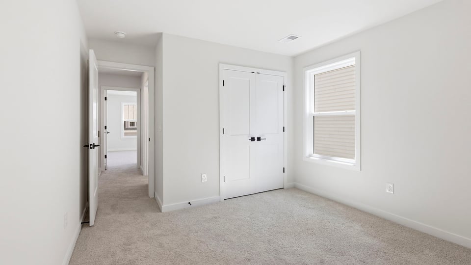 Bedroom with carpet and window.