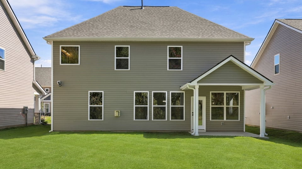 Back exterior of home with large backyard.