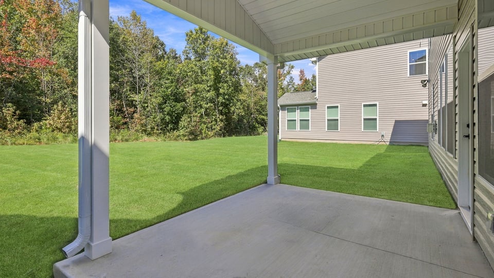 Back exterior of home with covered patio.