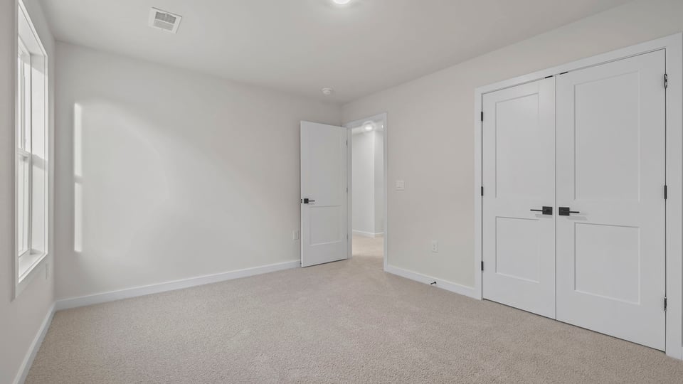 Bedroom with carpet and window.