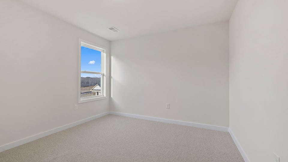 Bedroom with carpet and window.