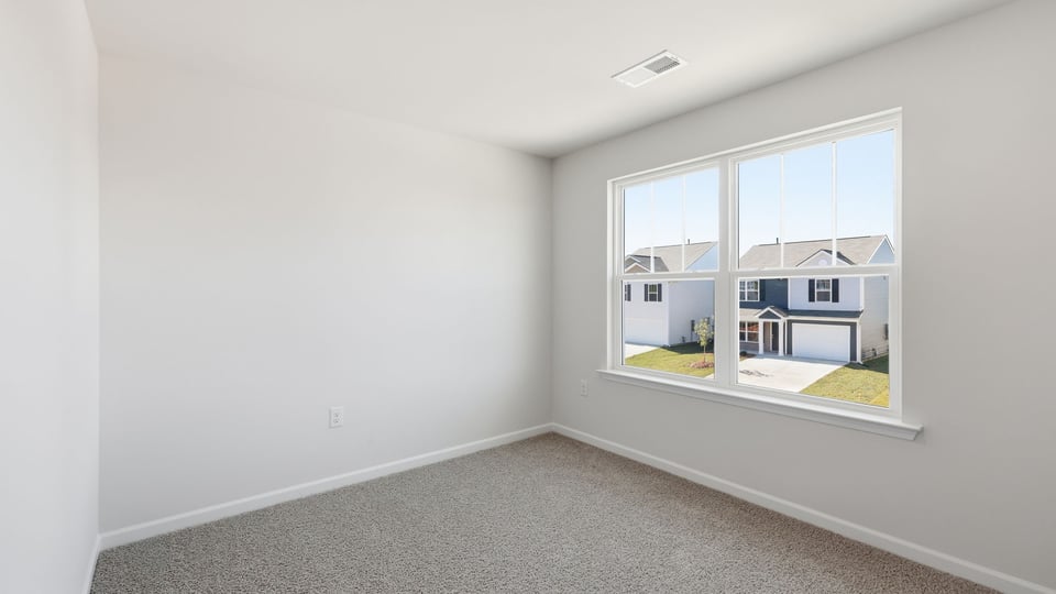 Bedroom with carpet and window.