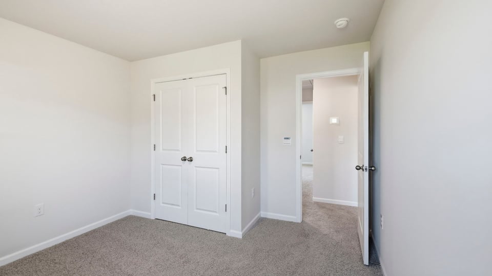 Bedroom with carpet and window.