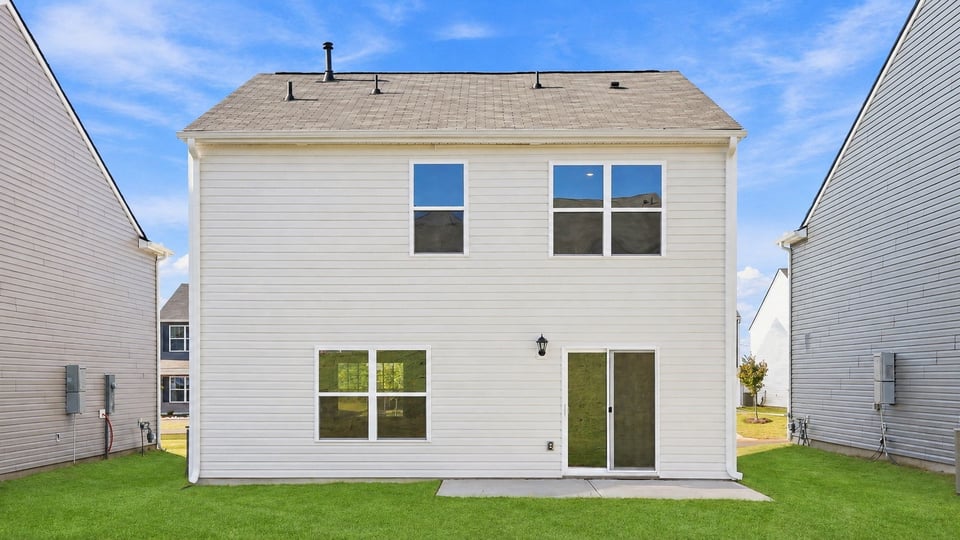 Back exterior of home with large backyard.