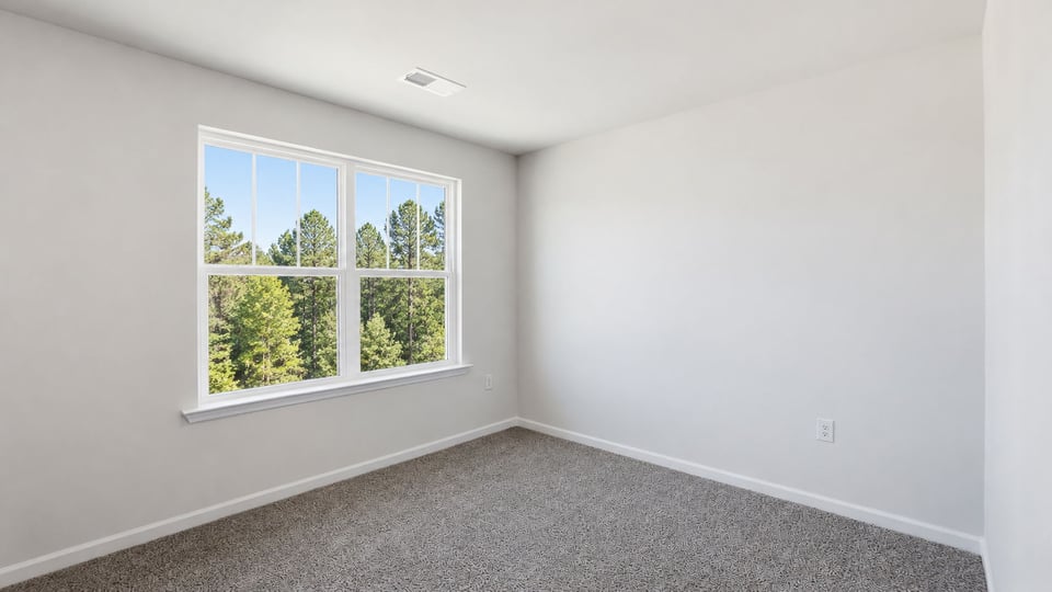 Bedroom with carpet and window.
