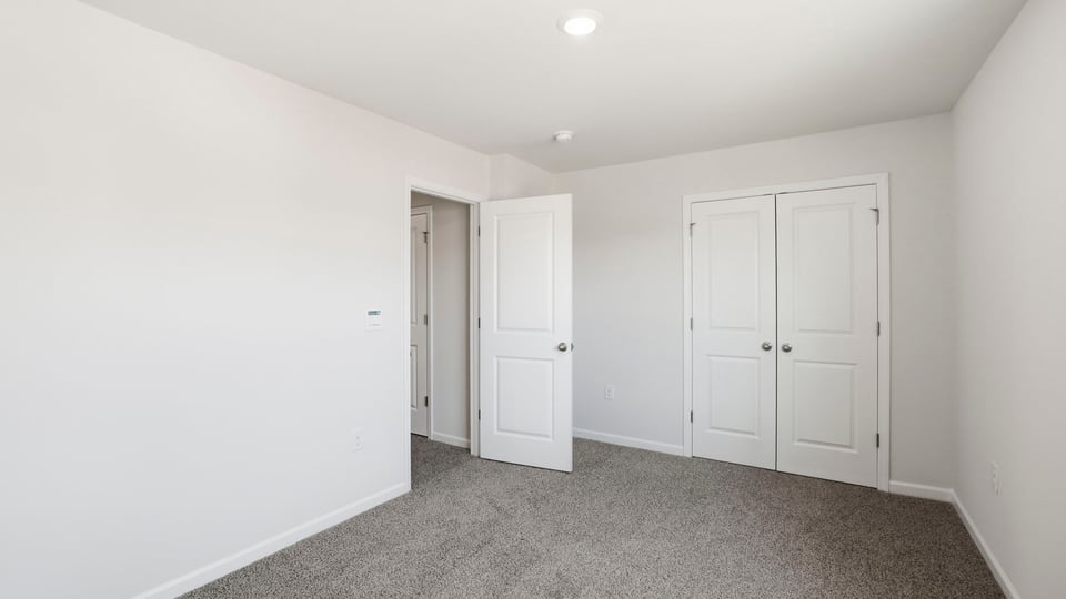 Bedroom with carpet and window.