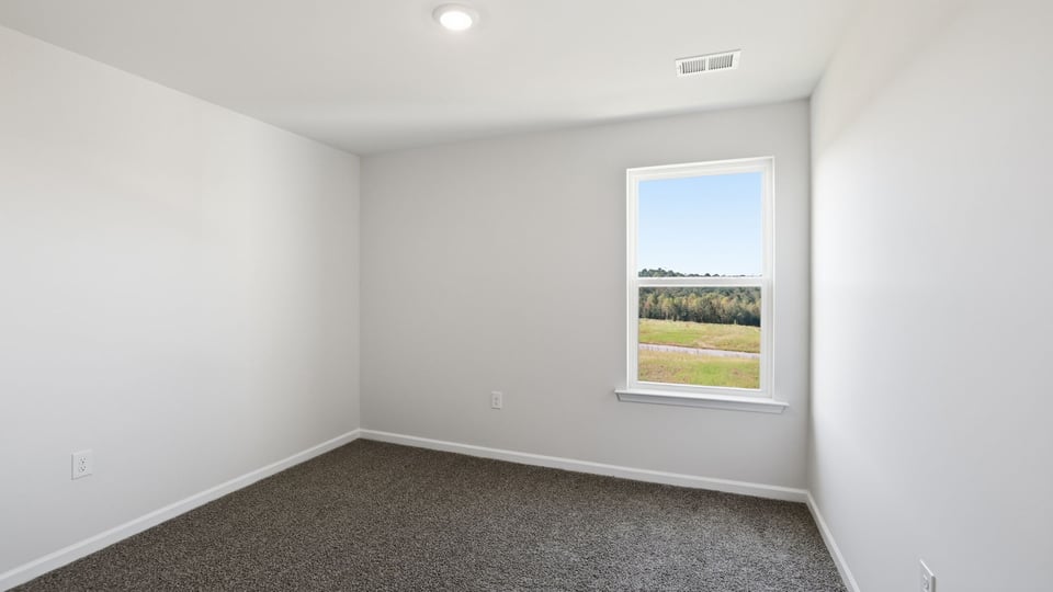 Bedroom with carpet and window.