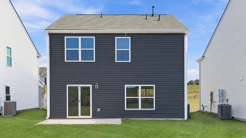 Back exterior of home with large backyard.