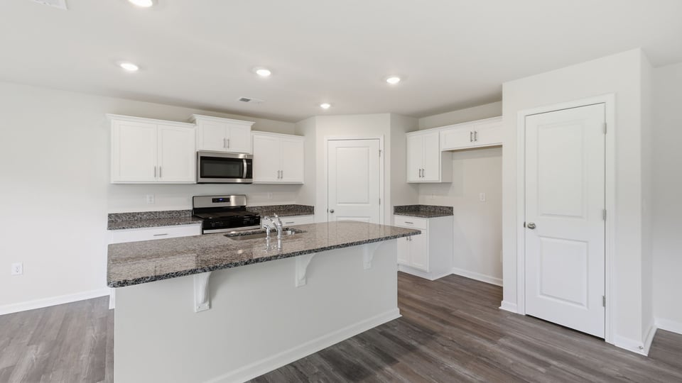 Kitchen and island with stainless steel appliances.