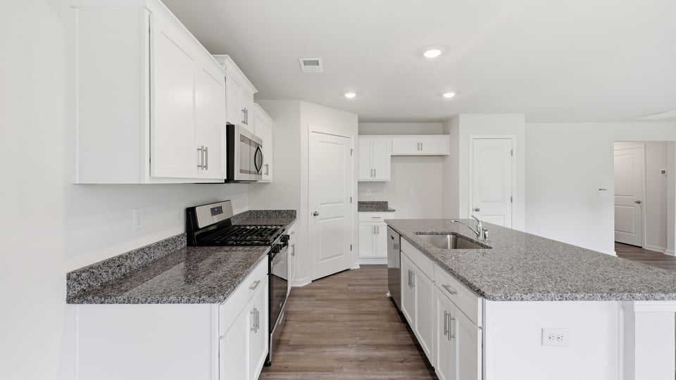 Kitchen and island with stainless steel appliances.