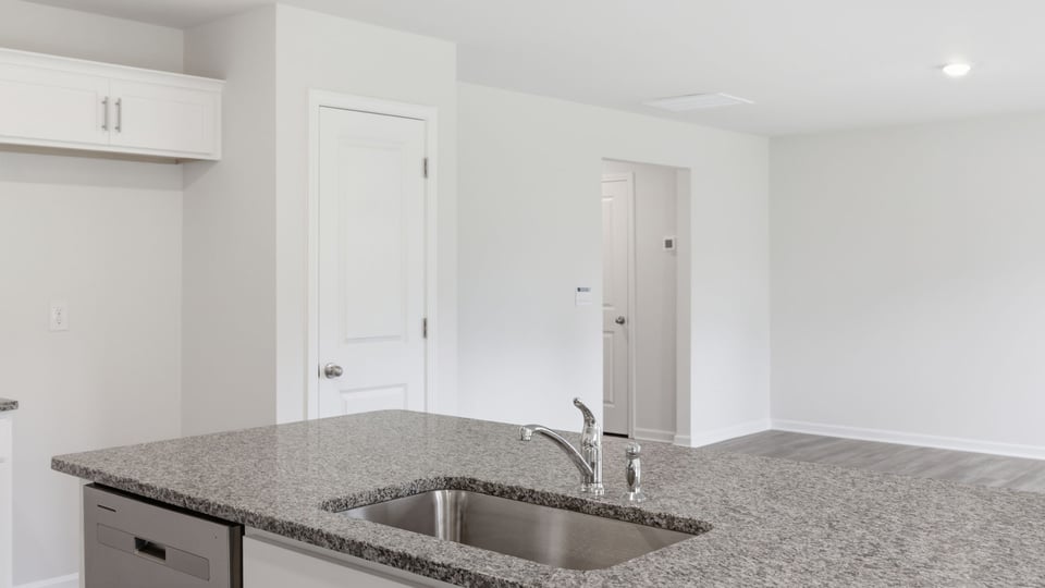 Kitchen and island with stainless steel appliances.