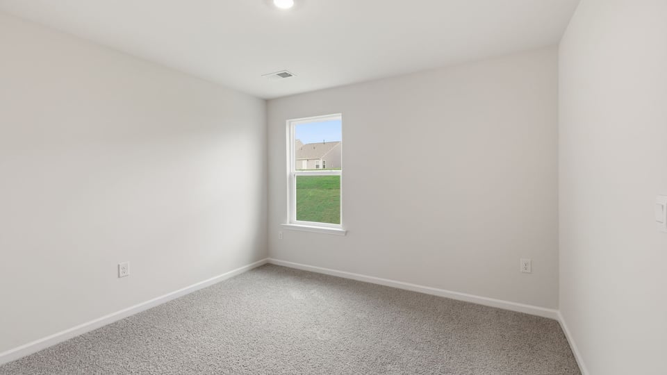 Bedroom with carpet and window.