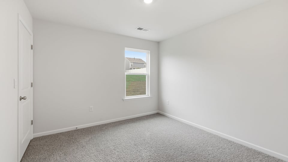 Bedroom with carpet and window.