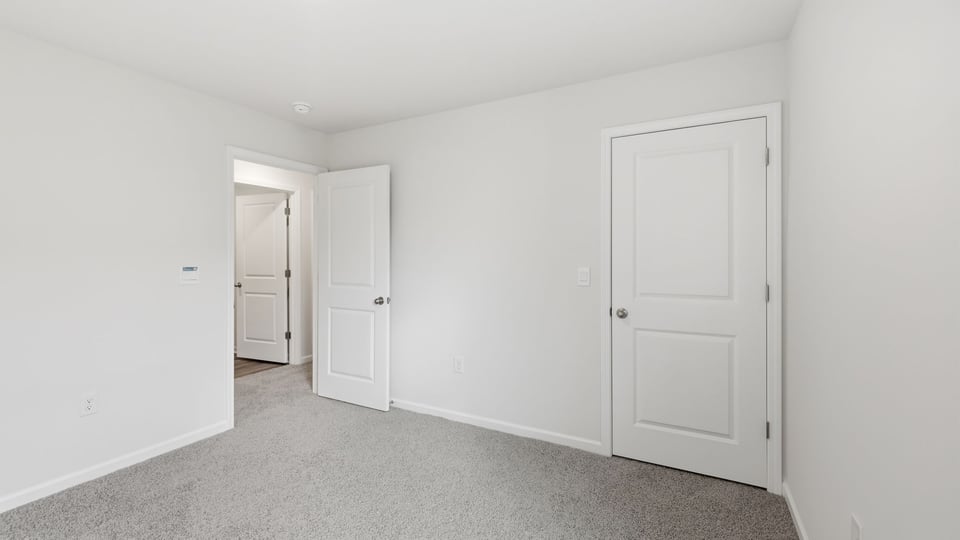 Bedroom with carpet and window.
